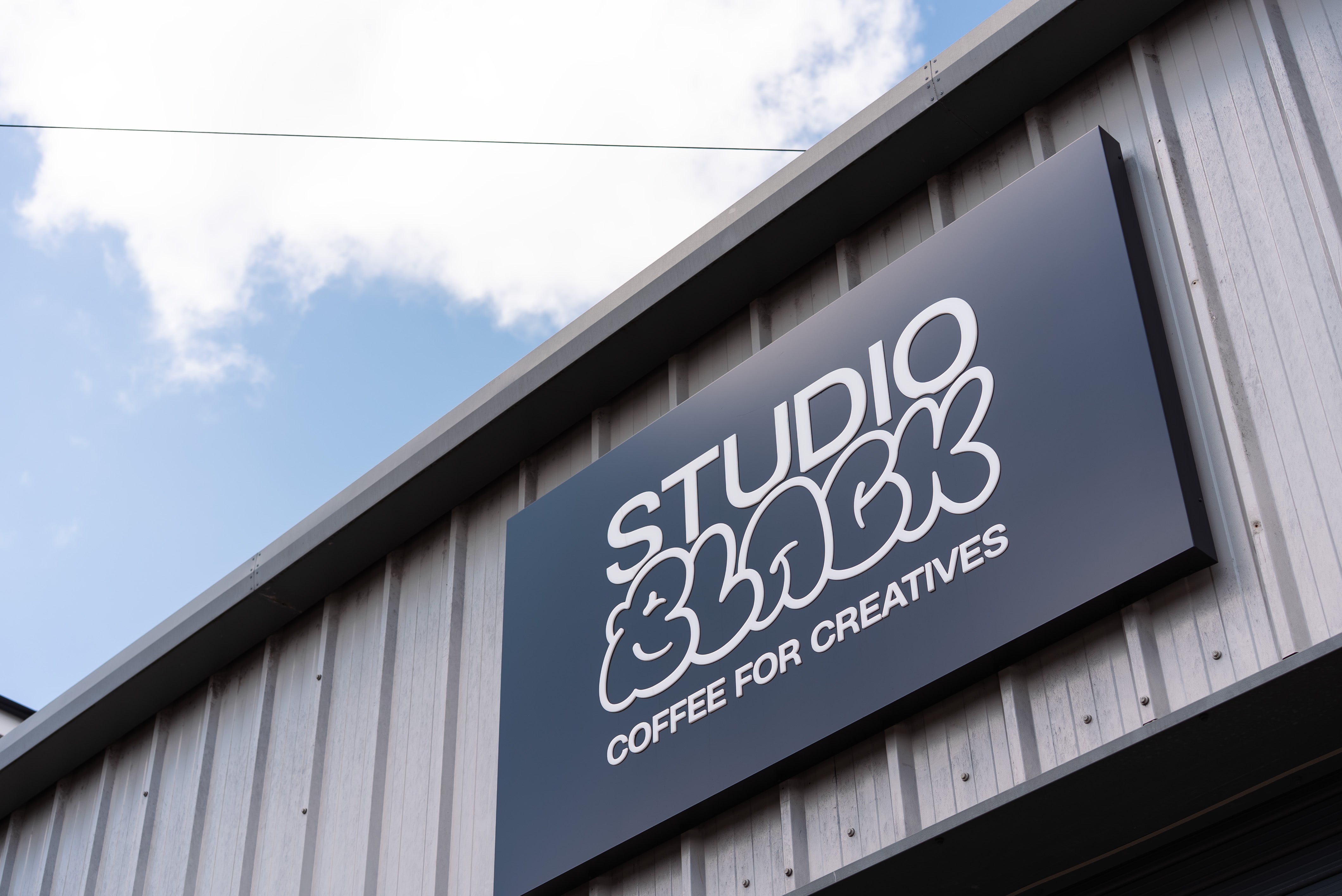 Studio Black sign on a building with a blue sky background